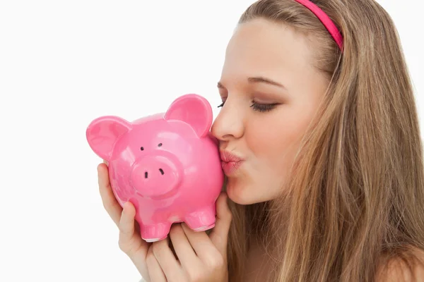 Close-up van een jonge vrouw een piggy-bank kussen — Stockfoto