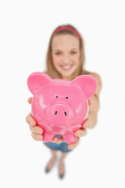 Fisheye view of a young woman tending a piggy-bank — Stock Photo, Image