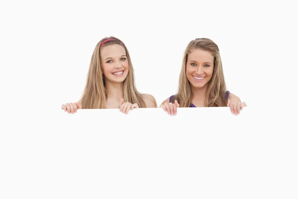 Крупним планом дві молоді жінки тримають порожній знак — стокове фото