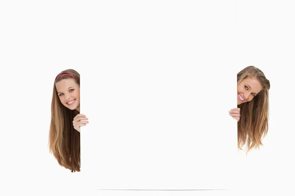 Two long hair women behind a blank sign — Stock Photo, Image