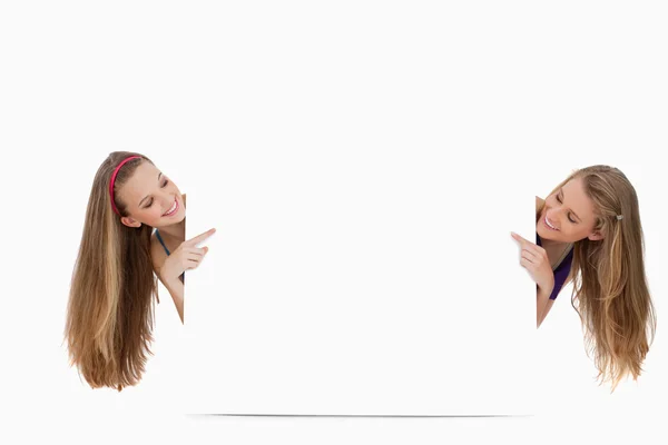 Twee lange haren vrouwen terug van een leeg teken — Stockfoto