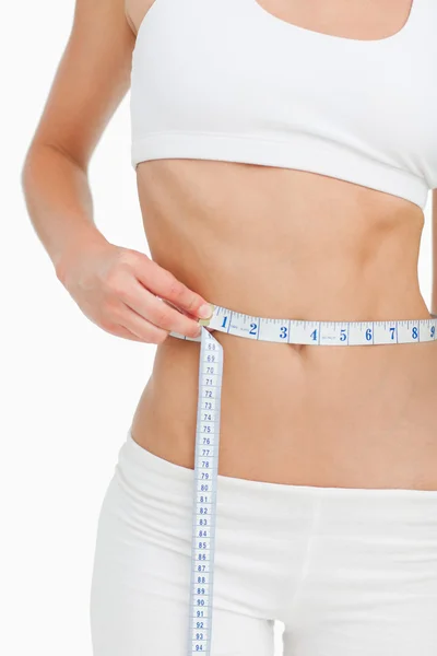 Close-up de uma mulher magra medindo sua cintura — Fotografia de Stock