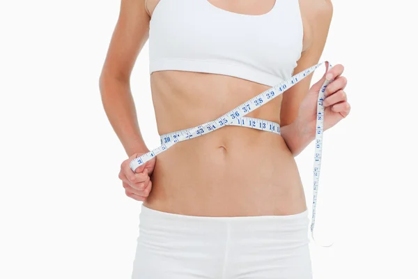 Primer plano de una mujer a dieta midiendo su cintura — Foto de Stock