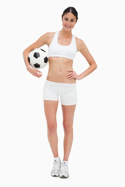 苗条的年轻女子在穿白衣服，拿着一个足球球 — 图库照片