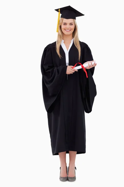 Estudante loira sorridente em roupão de graduação segurando seu diploma — Fotografia de Stock