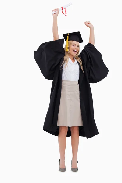Blond student i graduate mantel håller upp sin examen — Stockfoto
