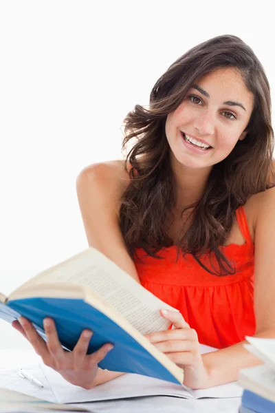 Porträtt av en vacker student som läser en blå bok — Stockfoto