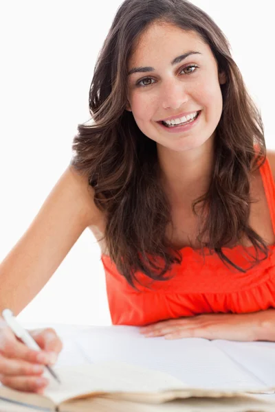 Retrato de una estudiante sonriente haciendo su tarea — Foto de Stock