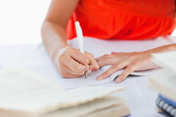 Nahaufnahme eines Kugelschreibers, den eine Studentin benutzt, um ihre Hausaufgaben zu machen — Stockfoto