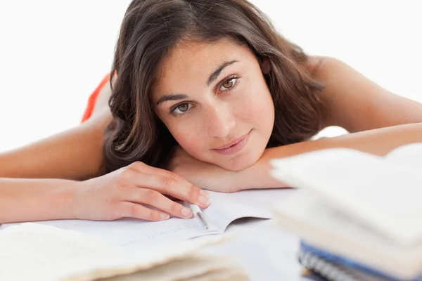 Porträtt av en vacker brunett huvudet på hennes läxor — Stockfoto