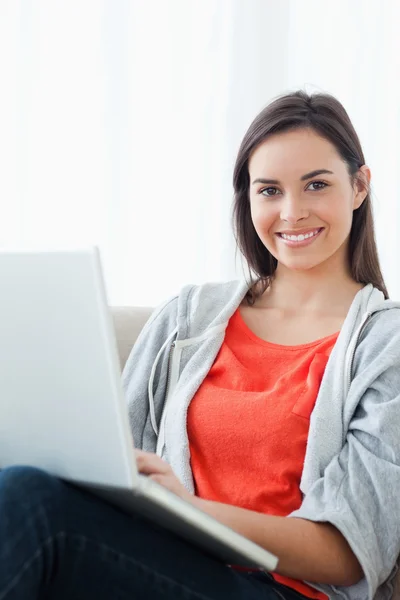 Яскраво усміхнена жінка використовує свій ноутбук — стокове фото