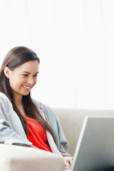 Крупним планом знімок усміхненої молодої жінки, використовуючи її ноутбук — стокове фото