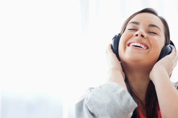 Смеющаяся женщина слушает наушники — стоковое фото