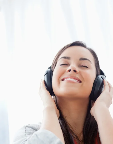 Gros plan d'une femme souriante écoutant ses écouteurs — Photo