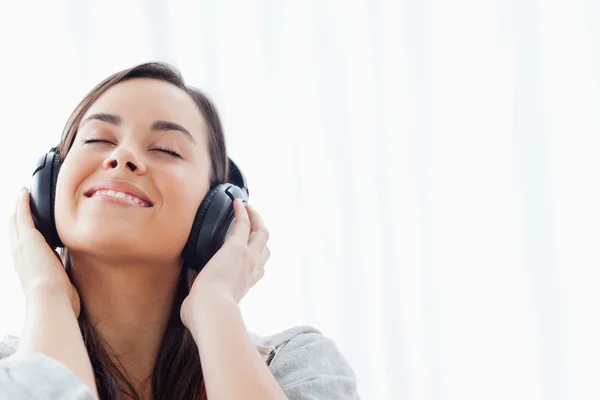 Usmívající se žena poslouchá její sluchátka — Stock fotografie