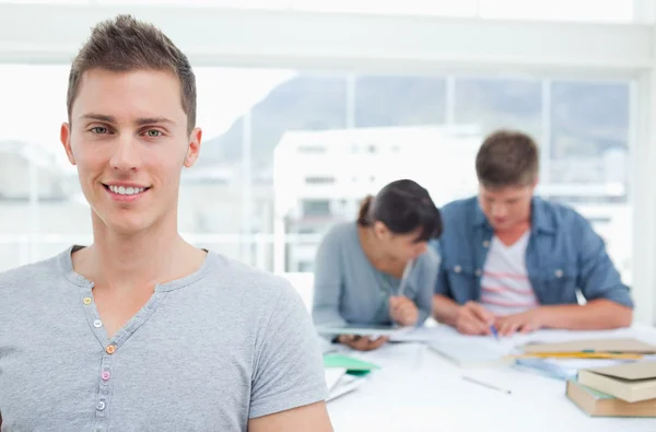 Student står framför hans studiekamrater och ler — Stockfoto