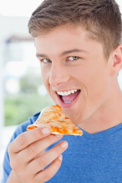 A man with his mouth open about to eat pizza and looking at the — Stock Photo, Image