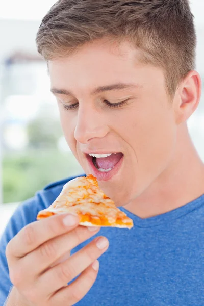 Bir dilim pizza onun önünde de onun hakkında bakarak bir adam — Stok fotoğraf