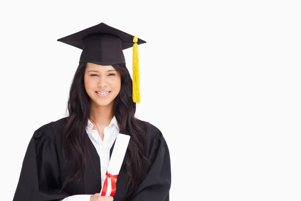 Una donna sorridente che guarda la macchina fotografica mentre indossa il suo gradu — Foto Stock