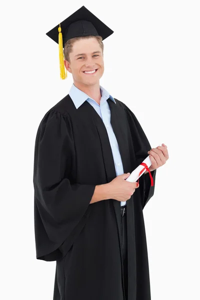 Ein lächelnder Mann, der in die Kamera schaut, als er sein Studium abschließt — Stockfoto