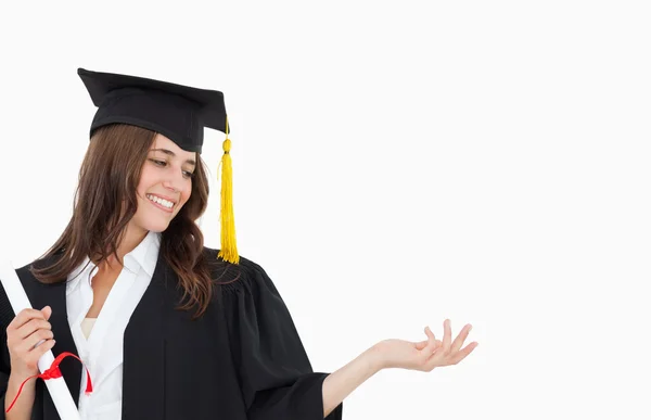 Une femme souriante avec un diplôme alors qu'elle ouvre son autre main — Photo