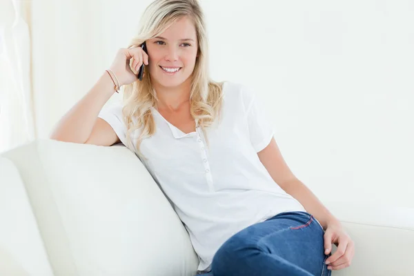 Una mujer hablando por teléfono y sonriendo mientras mira a la cara — Foto de Stock