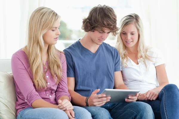 Three pay attention to the tablet in front of them — Stock Photo, Image
