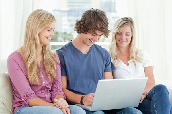 Man uses his laptop while the girls watch him — Stock Photo, Image