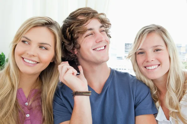 Three friends listening to a phone conversation — Stock Photo, Image