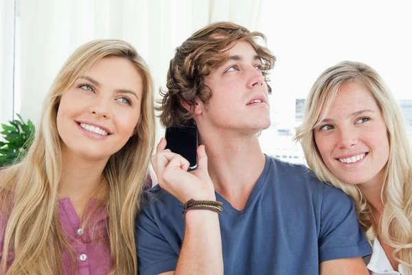 Três amigos ouvindo uma conversa telefônica — Fotografia de Stock