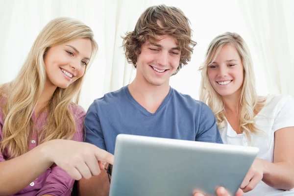 Three friends looking at the screen of the tablet — Stock Photo, Image