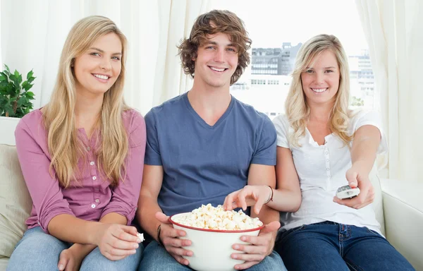 Three friends enjoying popcorn together — Stock Photo, Image