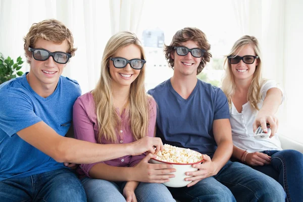Amigos sonriendo mientras comen palomitas de maíz y ven una película 3d — Foto de Stock