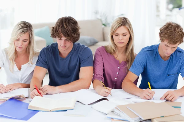 Vier studenten elkaar zitten en bestuderen — Stockfoto