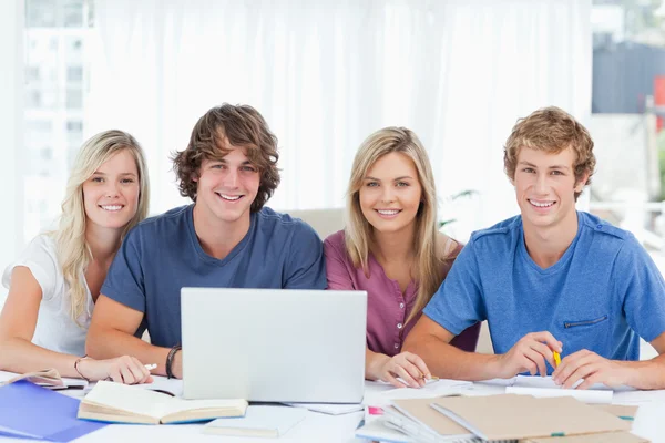 Een groep van studenten met een laptop kijken naar de camera — Stockfoto