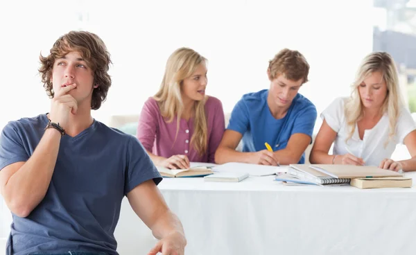 A young man sitting in front of his working class mates and thin — Stock Photo, Image
