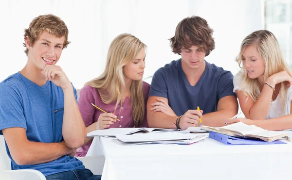 Um grupo de estudantes sentados juntos como todos eles estudam como um sm — Fotografia de Stock