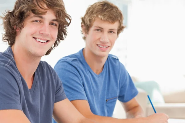 Två manliga studenter tittar in i kameran och leende — Stockfoto