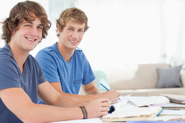 Ein paar männliche Studenten lächeln, während sie beide in die Kamera schauen — Stockfoto
