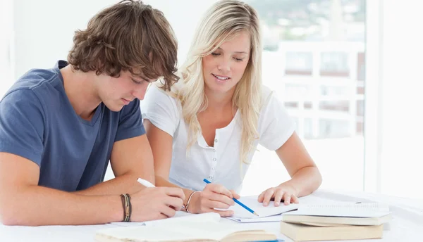 Мужчина и женщина работают вместе над домашним заданием — стоковое фото