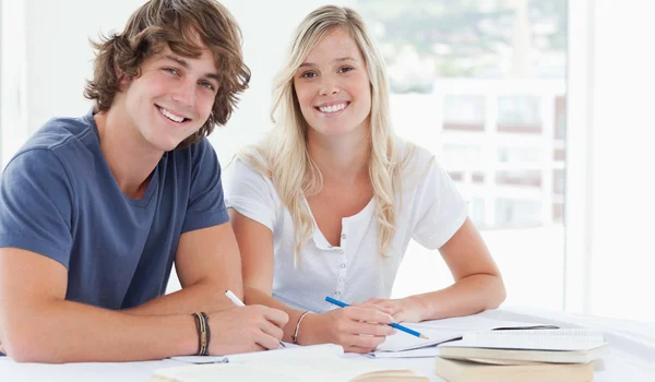 Smiling couple of students looking at the camera — Stock Photo, Image