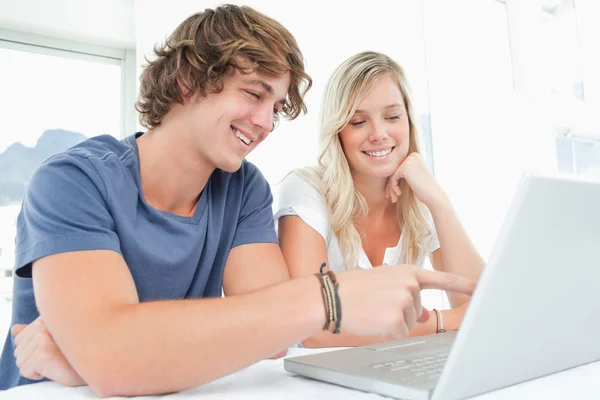 Посміхнена пара дивиться на ноутбук разом — стокове фото