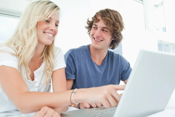 Пара использует ноутбук с мужчиной, смотрящим на женщину — стоковое фото
