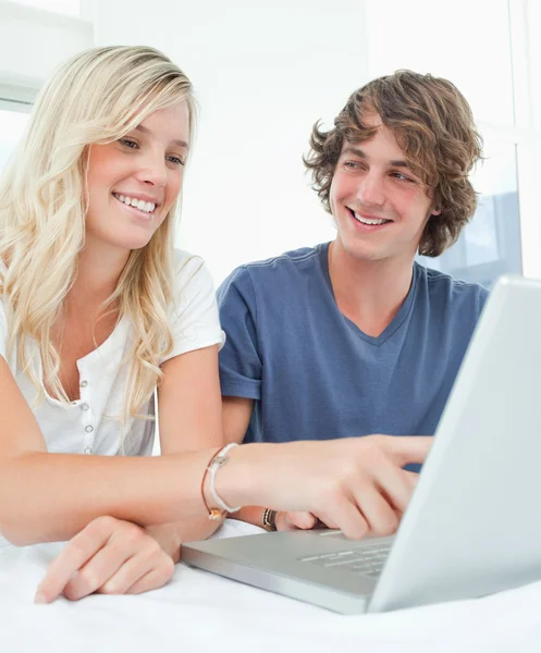Close up of a man looking at a woman as she points at the screen — Stock Photo, Image