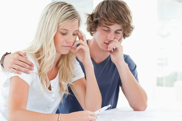 A worried couple holding a pregnancy test — Stock Photo, Image