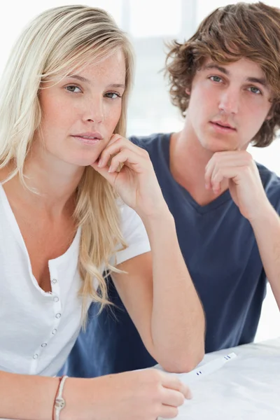 Una pareja preocupada con una prueba de embarazo mirando a la cámara — Foto de Stock