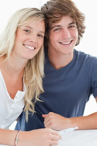 Um casal sorrindo segurando um teste de gravidez — Fotografia de Stock