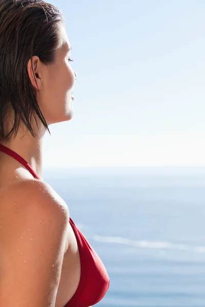 Frau im Bikini blickt aufs Meer — Stockfoto