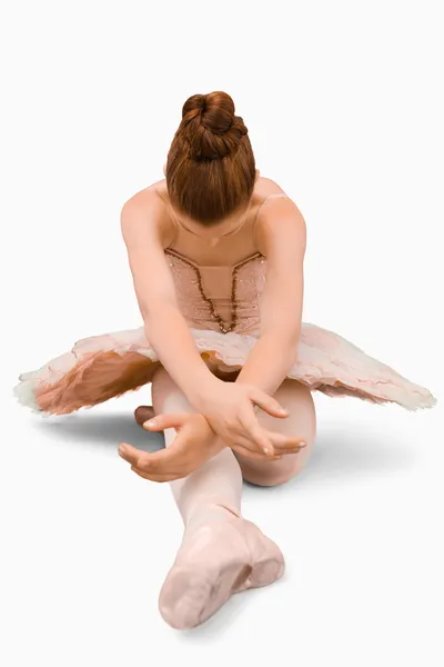 Сидящая балерина делает растяжки — стоковое фото