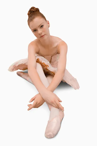 Балерина сидит на земле — стоковое фото